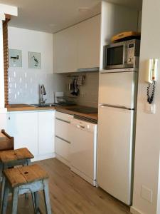 a kitchen with a white refrigerator and a microwave at Centro VIGO.NUEVO.TOP BEST VIEWS in Vigo