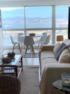 a living room with a couch and a table with chairs at Centro VIGO.NUEVO.TOP BEST VIEWS in Vigo