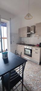 a kitchen with a table and a stove top oven at Appartamento luminoso, semplice con ogni comfort in Lido di Ostia