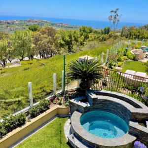 a swimming pool in a garden with a fountain at Rare Newport Coast Home for 7 weeks this Summer in Newport Beach