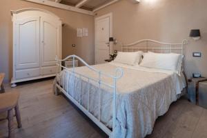 ein Schlafzimmer mit einem Bett mit einem weißen Bettrahmen in der Unterkunft AGRIB&B Il Pomo d'oro in Assemini