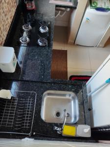 a kitchen counter with a sink and a stove at Condomínio DINASEG in Rio Branco
