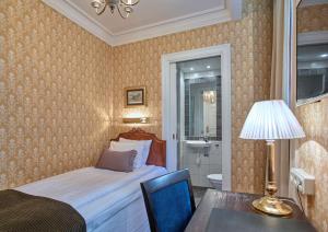a bedroom with a bed and a table and a lamp at Scandic Gamla Stan in Stockholm