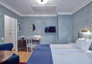 a bedroom with a bed and a table and a desk at Scandic Gamla Stan in Stockholm
