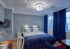 um quarto com uma cama com um edredão azul em Scandic Gamla Stan em Estocolmo