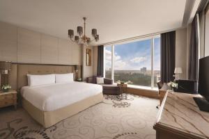 a hotel room with a bed and a large window at Shangri-La Bengaluru in Bangalore