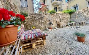 einen Garten mit einem Stuhl und Blumen vor einem Gebäude in der Unterkunft Filoxenos Houses Corfu Island in Mantoúkion