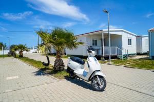 a white scooter parked in front of a house at Urban Art by Campigir in Peniche