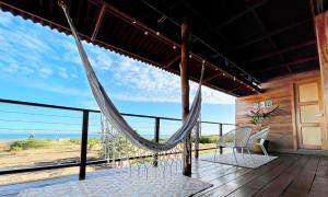 Dibulla的住宿－Corazon Guajiro Cabaña frente a Playa Solitaria en Dibulla cerca a Palomino - Cabin in front of Solitary Beachs，一个带吊床的门廊,享有海景