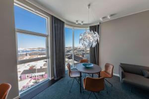 a dining room with a table and chairs and a large window at Best Western Plus Hotel Ilulissat in Ilulissat
