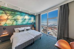 a hotel room with a large bed and a large window at Best Western Plus Hotel Ilulissat in Ilulissat