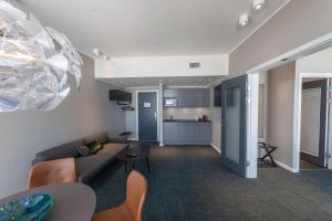 a living room with a couch and a kitchen at Best Western Plus Hotel Ilulissat in Ilulissat