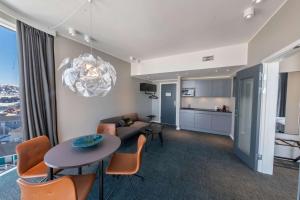 a living room with a table and chairs and a kitchen at Best Western Plus Hotel Ilulissat in Ilulissat