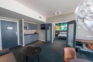 a hotel room with a bed and a kitchen and a bedroom at Best Western Plus Hotel Ilulissat in Ilulissat