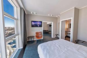 a hotel room with a bed and a view of a city at Best Western Plus Hotel Ilulissat in Ilulissat