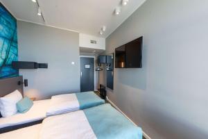 a bedroom with two beds and a flat screen tv at Best Western Plus Hotel Ilulissat in Ilulissat