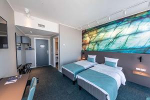 a hotel room with two beds and a large painting on the wall at Best Western Plus Hotel Ilulissat in Ilulissat