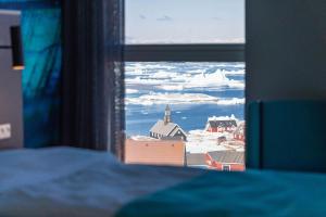 a view of a town from a bedroom window at Best Western Plus Hotel Ilulissat in Ilulissat
