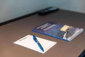 a pen sitting on top of a desk with a book at Best Western Plus Hotel Ilulissat in Ilulissat