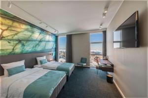 a hotel room with two beds and a large window at Best Western Plus Hotel Ilulissat in Ilulissat
