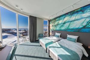 a bedroom with two beds and a large window at Best Western Plus Hotel Ilulissat in Ilulissat