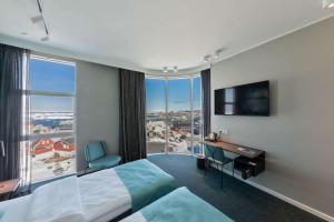 a hotel room with a bed and a desk and a large window at Best Western Plus Hotel Ilulissat in Ilulissat +37 photos