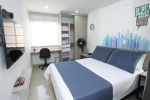 Un dormitorio con una cama azul y blanca y una ventana en New Studio Apartment for Two en Medellín