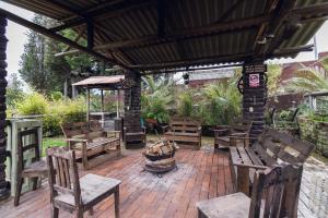 a patio with wooden benches on a brick patio at Campo Wasi in Riobamba