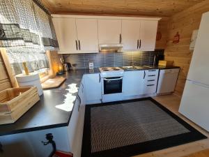 a kitchen with white cabinets and a stove top oven at Hygge på fjellet in Øyuvstad +33 photos