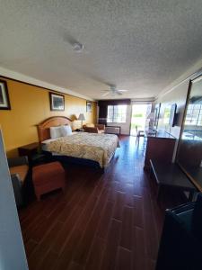 a hotel room with a bed and a desk at Deluxe Inn and Suites in Raymondville