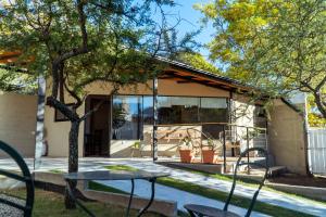 a table and chairs in front of a house at Complejo Quiya - Departamento Los Espinillos con hidromasaje in Alta Gracia