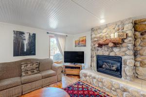 een woonkamer met een stenen open haard en een bank bij Oso Lodge Unit B in Yosemite West