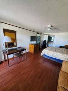 a hotel room with a bed and a desk at Deluxe Inn and Suites in Raymondville