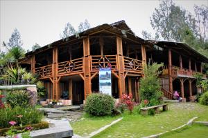 une maison en bois avec un panneau devant elle dans l'établissement Hotel Agrowisata Kopeng Gunungsari, à Kopeng