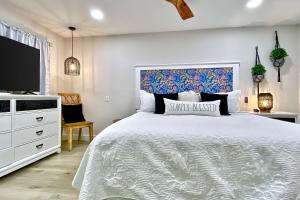 a bedroom with a white bed and a tv at Pipers Run 7 in Clearwater Beach