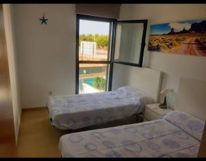 a room with two beds and a window at Chalet Alcocebre Residencial Dulcinea in Alcossebre +45 photos
