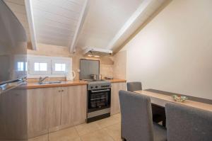 eine Küche mit Herd und Tisch mit Stühlen in der Unterkunft Brunswick Villa Units Party & Wedding Complex by "elite" in Laganas