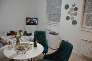 a living room with a table and green chairs at SARAJEVO Tower 21 NEW AND UNIQUE in Sarajevo