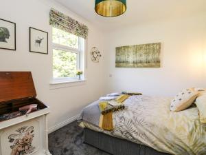 um quarto com uma cama e um piano em Kilmartin View em Lochgilphead