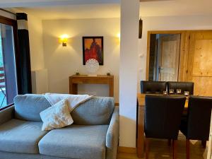 Una sala de estar con un sofá azul y una mesa. en Le REFUGE DES PORTES DU MONT BLANC, en Vallorcine 20 fotos más