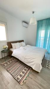 1 dormitorio con 1 cama blanca grande y 1 alfombra en Albina's luxury Villa 3 bedroom, en Chaniotis
