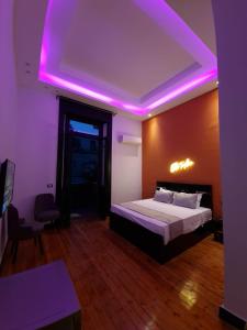 sypialnia z łóżkiem z fioletowymi lampkami na suficie w obiekcie Kmt Hostel w Kairze