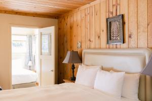 a bedroom with a white bed and wooden walls at Fernwood Resort in Big Sur