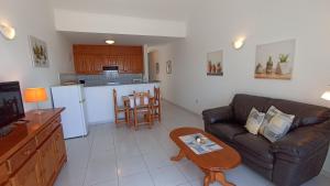 ein Wohnzimmer mit Sofa und Tisch in der Unterkunft Apartments Casa Blanca in Charco del Palo