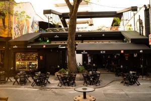 un grupo de mesas y sillas frente a un restaurante en Garoa Hostel, en São Paulo