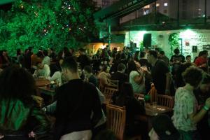Eine Menschenmenge, die in einem Restaurant an Tischen sitzt. in der Unterkunft Garoa Hostel in São Paulo