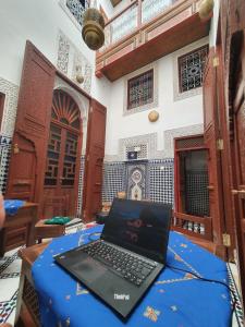 a laptop computer sitting on a table in a room at Dar atlas in Fès