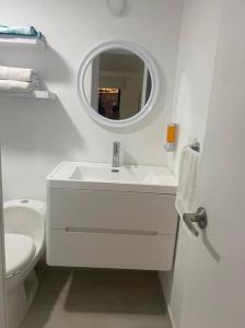 a white bathroom with a sink and a mirror at Hermoso apartamento recién remodelado zona top in San Andrés