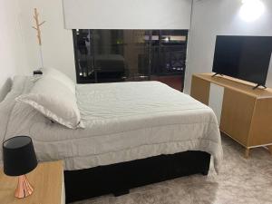 a bedroom with a bed and a flat screen tv at Hermoso apartamento recién remodelado zona top in San Andrés