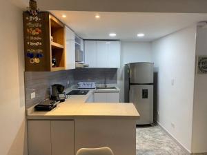 a kitchen with white cabinets and a refrigerator at Hermoso apartamento recién remodelado zona top in San Andrés